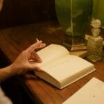 Biurko pisarza z książką, kałamarzem i starą lampą w ciepłym świetle