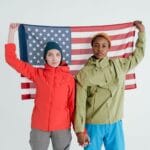 Dwoje młodych dorosłych pozuje z flagą USA w studiu