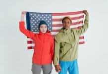 Dwoje młodych dorosłych pozuje z flagą USA w studiu