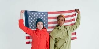 Dwoje młodych dorosłych pozuje z flagą USA w studiu