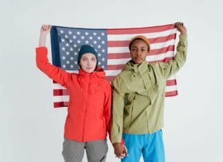 Dwoje młodych dorosłych pozuje z flagą USA w studiu