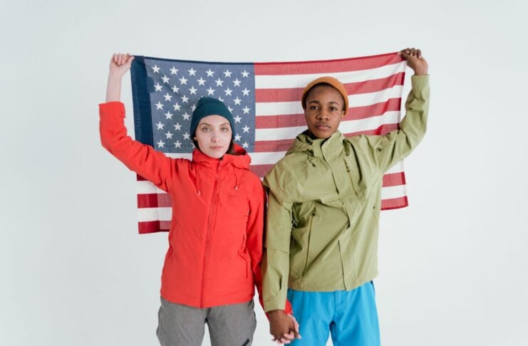 Dwoje młodych dorosłych pozuje z flagą USA w studiu