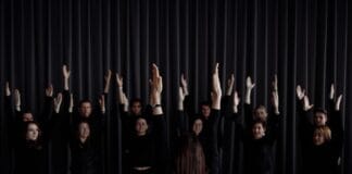 Młodzieżowa grupa teatralna ćwiczy scenę z uniesionymi ramionami