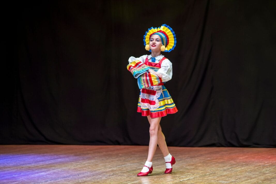 Tancerka ludowa w barwnym stroju tradycyjnym na scenie