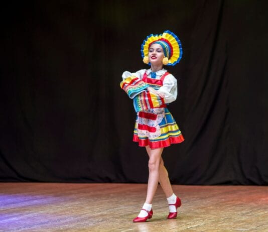 Tancerka ludowa w barwnym stroju tradycyjnym na scenie