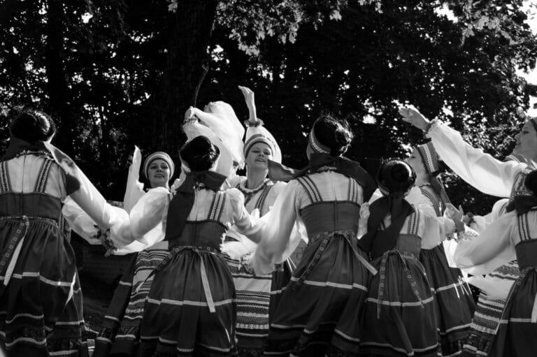 Tancerze w strojach ludowych podczas ceremonii na świeżym powietrzu